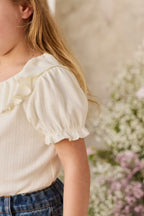 Haut en coton et élasthanne pointelle bio coloris parchemin sobre avec encolure et poignets festonnés pour fille de 6 mois à 8 ans